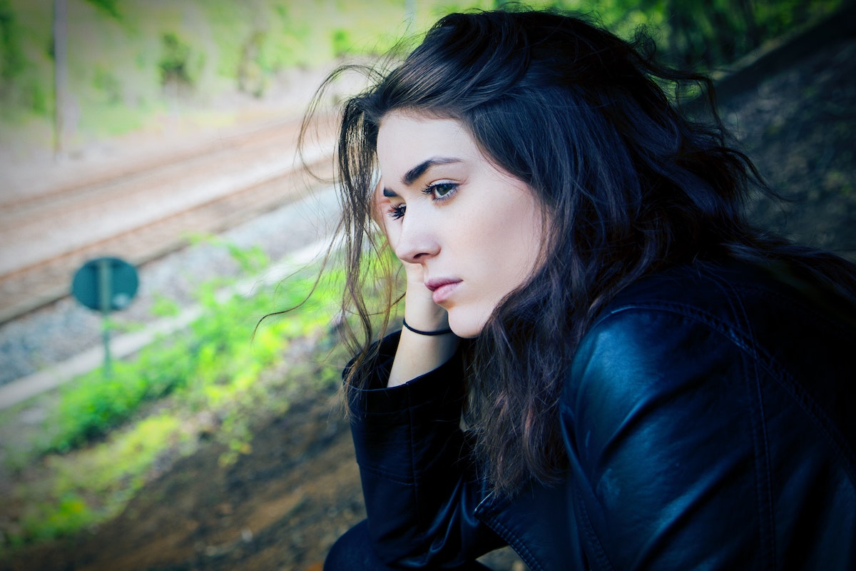 sad-depressed-woman-in-leather-jacket-looking-at-road